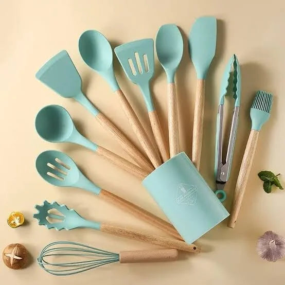 Set of turquoise silicone kitchen utensils with wooden handles on a beige background