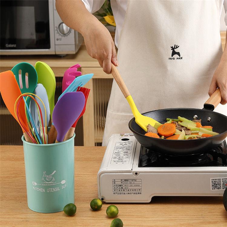 Person cooking in a kitchen with colorful utensils and a wok filled with vegetables.