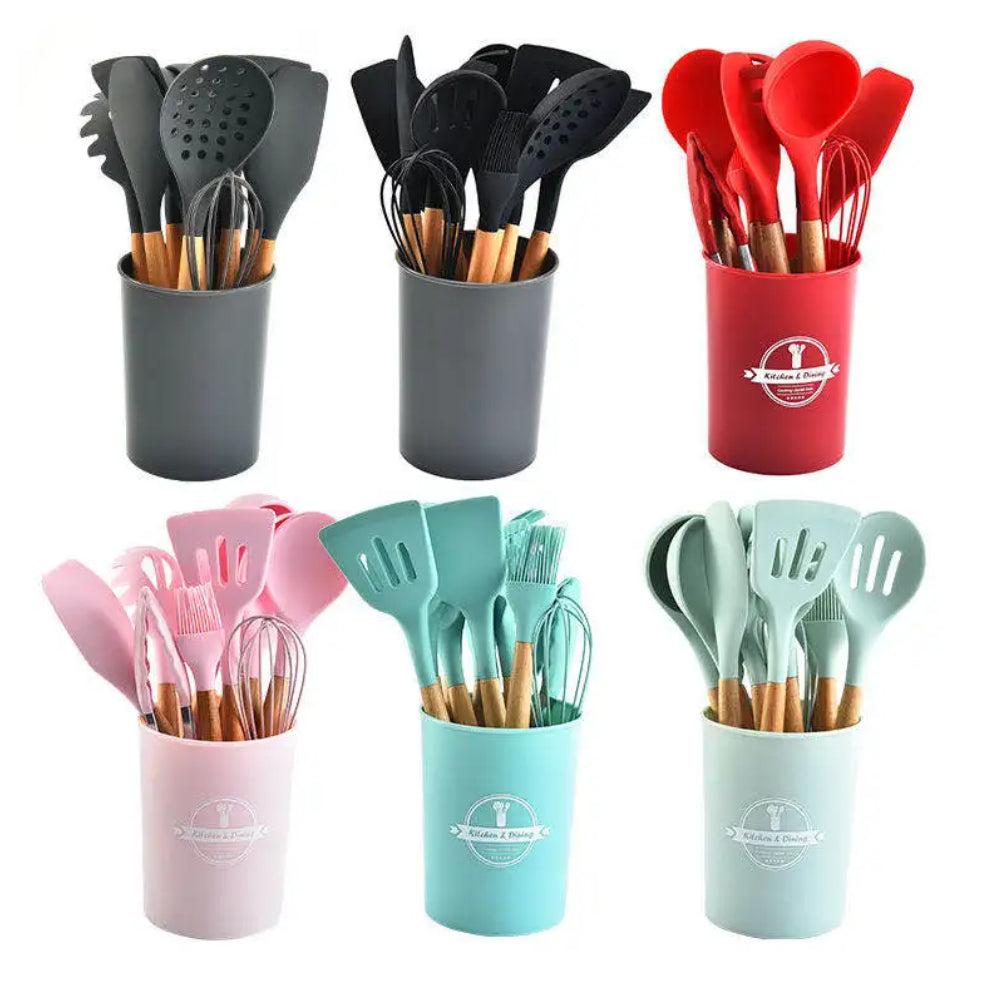 Set of kitchen utensils in colorful holders on a white background