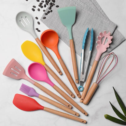 Colorful kitchen utensils including spatulas, spoons, and tongs on a light gray background.